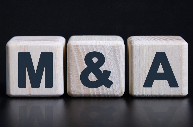 Wooden blocks displaying the letters M & A, representing mergers and acquisitions in business and corporate finance.
