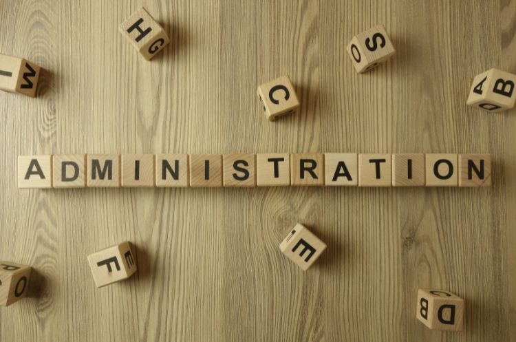 Wooden letter blocks spelling 'ADMINISTRATION' on wooden surface, symbolizing strategic role and importance of administrative managers in modern organizations