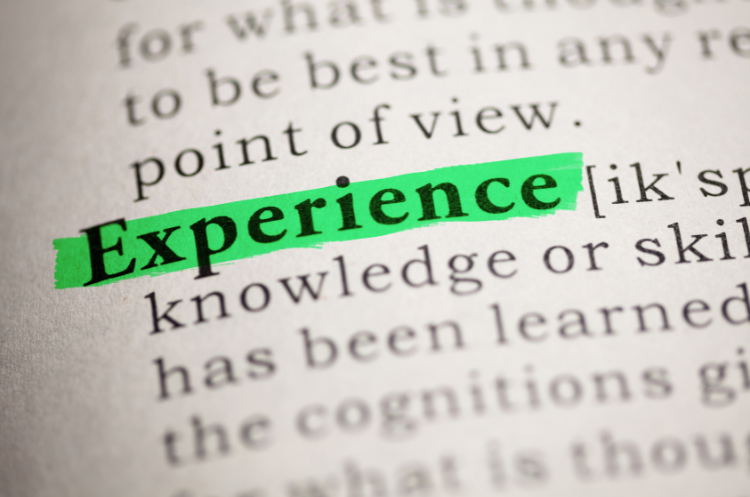 The word 'Experience' is highlighted in green on a dictionary page, illustrating the concept of leveraging decades of experience in new roles.