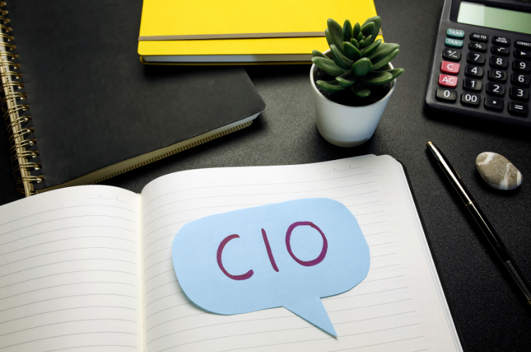 Workspace with calculator and notebook displaying the acronym CIO for Chief Information Officer.