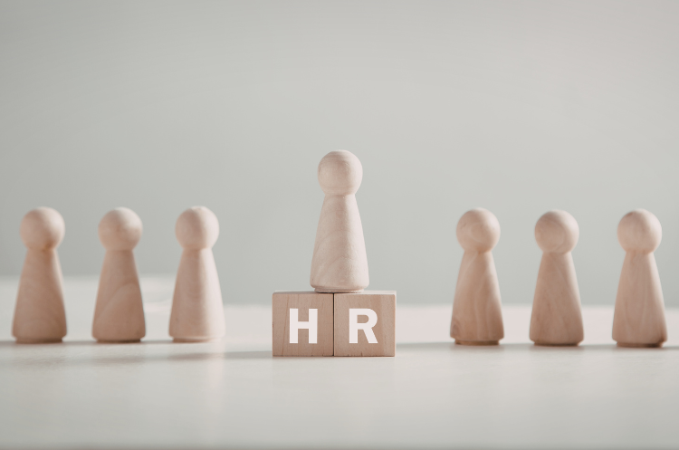 Illustration of an Internal and External Recruitment strategy showing a line of black human figures, with one blue figure centered and magnified by a magnifying glass, symbolizing the hiring process and candidate selection.