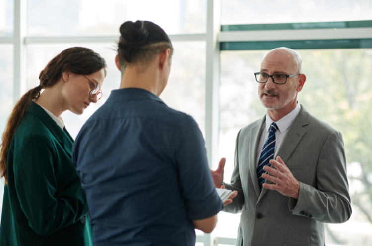 A professional business meeting in a Singapore office featuring a corporate consultant explaining the role of a nominee director to two entrepreneurs.