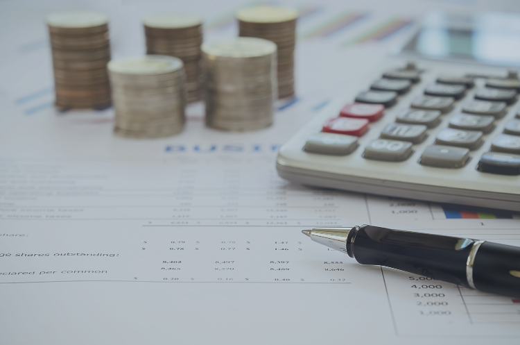 Financial documents with a calculator, pen, and stacked coins representing financial planning and financial advisor careers in Singapore.