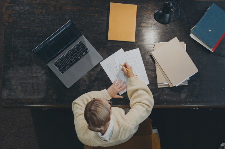 Professional working at a desk with documents and a laptop, representing administrative executive roles and second-career opportunities in Singapore.