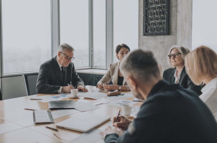 Experienced business leaders and advisors collaborating in a boardroom meeting, discussing strategy and business growth, representing the benefits of an advisory board for companies.