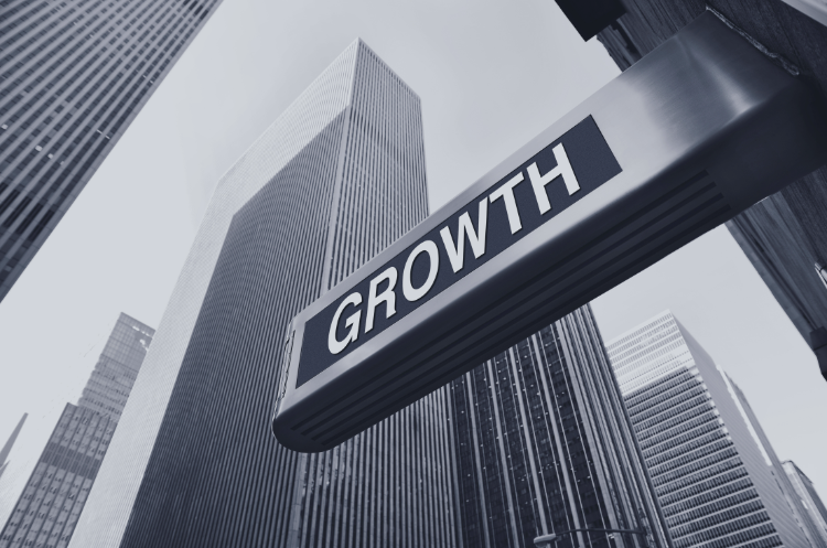 Business growth consultant concept with a “GROWTH” sign against a backdrop of skyscrapers.