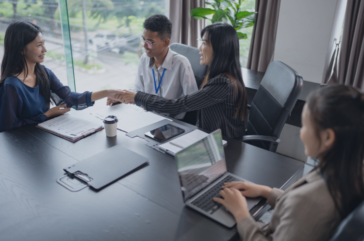 Business professionals shaking hands during a corporate meeting, representing collaboration and risk management roles in Singapore.